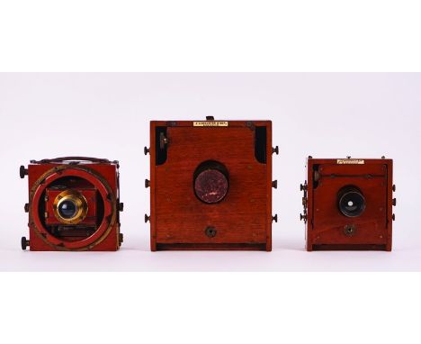 THREE MAHOGANY &amp; BRASS PLATE CAMERASEarly 20th CenturyTwo with maker's labels detailed ' J. LANCASTER &amp; SONS', the la