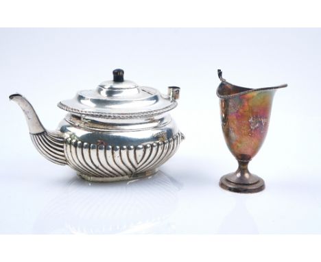 A SILVER TEAPOT AND A SILVER CREAM JUG (2)The teapot of oval form, with partly fluted decoration and with a gadrooned rim, th