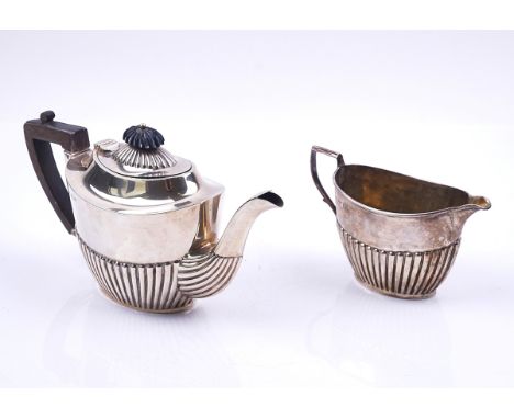 A SILVER TEAPOT AND A MATCHING MILK JUG (2)Each piece of oval form, with partly fluted decoration, the teapot with compositio