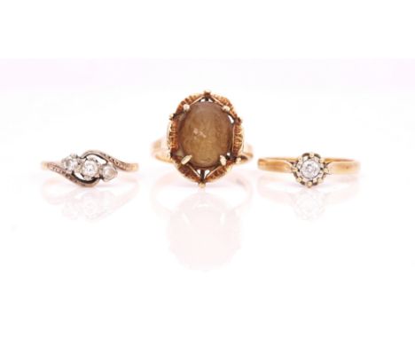 A GOLD AND DIAMOND THREE STONE RING AND TWO FURTHER GOLD AND GEM SET RINGS (3)The diamond three stone ring claw set with a ro