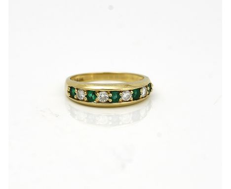 A GOLD, EMERALD AND DIAMOND NINE STONE HALF HOOP RINGClaw set with five circular cut emeralds, alternating with four circular