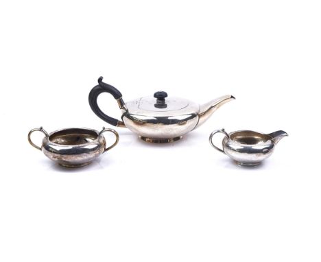 A SILVER THREE PIECE TEA SET (3)Of compressed circular form, undecorated, the teapot with wooden fittings. Chester 1907, gros