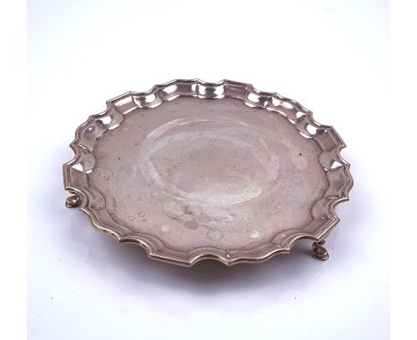 A SILVER SALVER OF SHAPED CIRCULAR FORMDecorated with a Chippendale style pie crust rim and raised on three pad feet, diamete