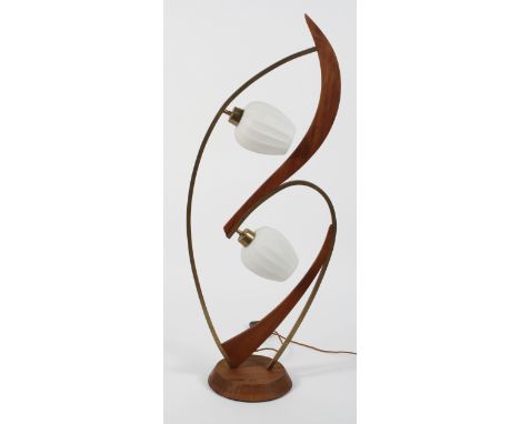 A mid 20th century Danish teak and brass floor standing lamp, having a round and bevelled base with curved forms atop and bud