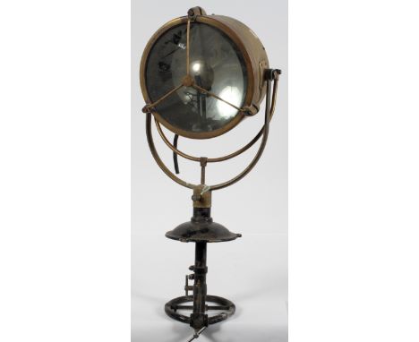A brass spotlight, possible from a ship, with a 25cm mirrored lamp, black painted handle and spout, total height 76cm