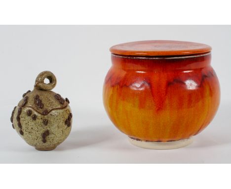 A Poole pottery style biscuit barrel, glazed in flowing orange, 16cm high; together with a Studio pottery oatmeal glazed eart
