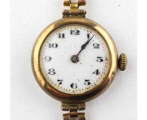 A yellow metal wristwatch. Circular white 25.0mm dial with numerical markings. Manual wind movement. Case hallmarked 9ct gold