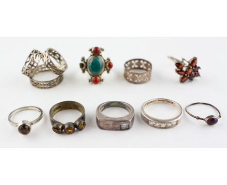A collection of eight rings of variable designs, size ranges from J to R and a scarf ring. Some marked for silver. Gross weig