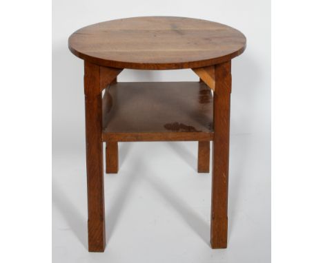 An Arts and Crafts oak circular occasional table, with chamfered legs and a shelf, 63cm high x 60cm diameter