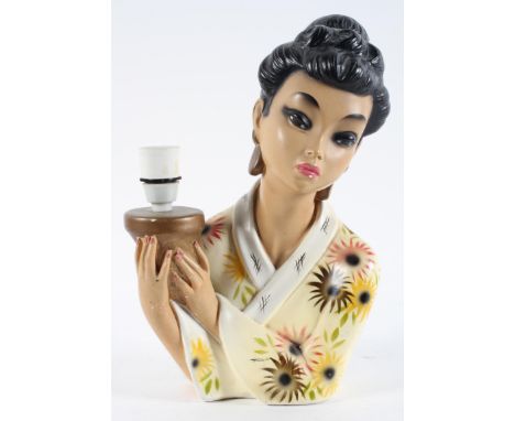 A 1950's plaster lamp, modelled as a Japanese lady holding the sconce, Incised Rgd. 906384, 35cm high