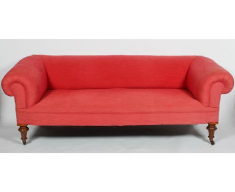 A Victorian Chesterfield sofa, with scrolling arms and back on turned walnut legs, in a salmon pink upholstery, 78cm high x 2