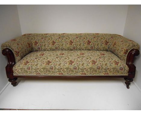 A Victorian mahogany framed three seater settee, floral tapestry upholstery, carved scroll arms, melon feet with porcelain ca