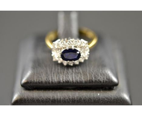 An 18ct gold ring with central sapphire surrounded by eighteen diamonds in cluster setting - size M. CONDITION REPORT: Good c