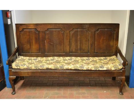 An eighteenth century oak settle with four panels to back, scroll arms, metal mesh seat and cabriole legs - Height 110cm, Len