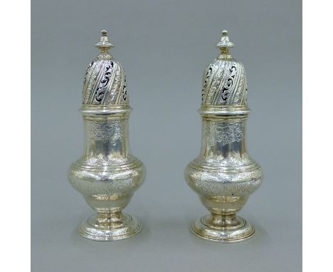 A pair of George II silver castors, hallmarked for London 1744, maker's mark of SW. 16 cm high. 464.4 grammes.