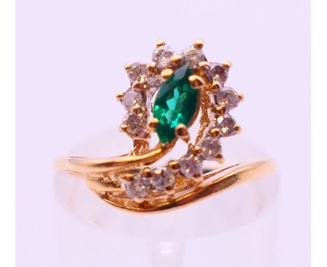 An unmarked probably 18 ct gold emerald and diamond ring. Ring size J.