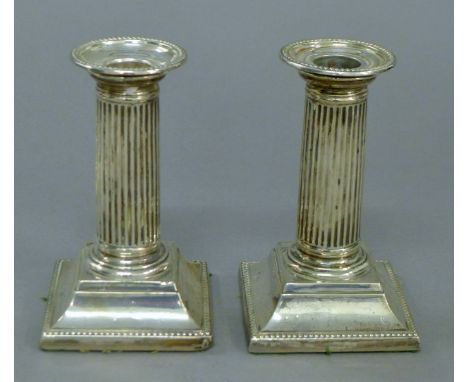 A pair of silver candlesticks. 12.5 cm high.