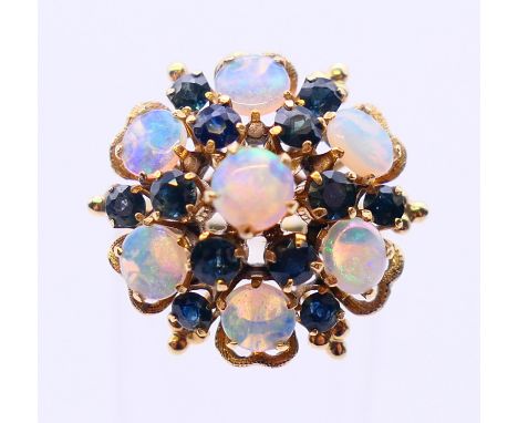 An 18k opal and sapphire cluster ring. Ring size L/M.