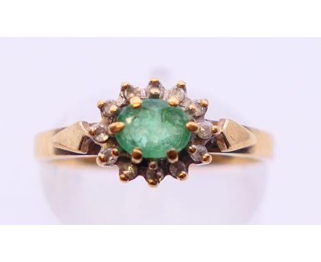 A 9 ct gold diamond and emerald ring. Ring size M.