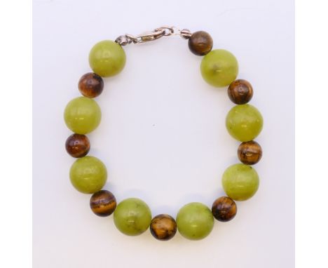 A silver jade and tiger's eye bracelet.  18 cm long. 