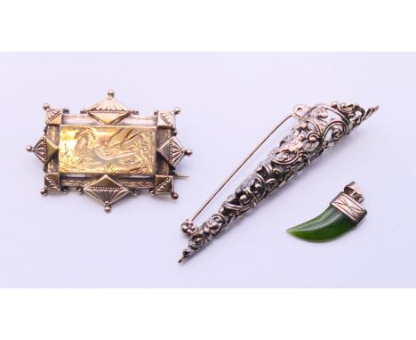 A Victorian silver brooch, a posy holder brooch and a silver and jade tiger tooth shaped pendant.  Brooch 4.5 cm wide, posy h
