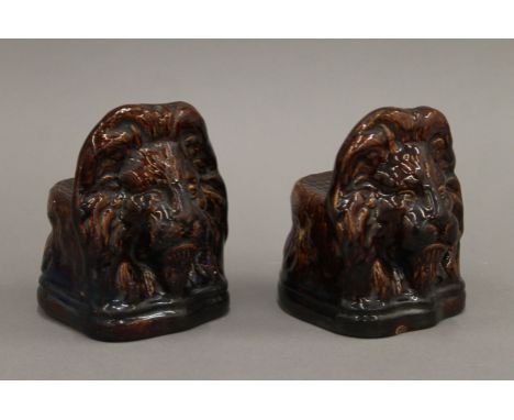 A pair of 19th century treacle glazed pottery lion's head sash window stoppers. 13.5 cm high. 
