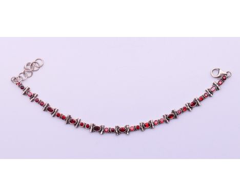 A silver and garnet bracelet.  22 cm long (maximum).