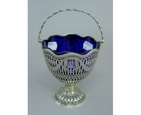 A Georgian silver bonbon basket with repaired blue glass liner. 12 cm high. 5.6 troy ounces.