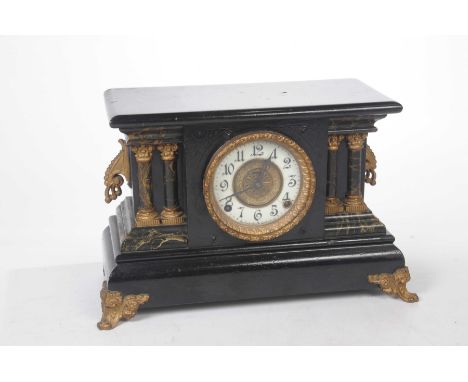 An early 20th Century black wooden mantel clock The rectangular topped clock, with white enamel dial and Arabic numerals, fla