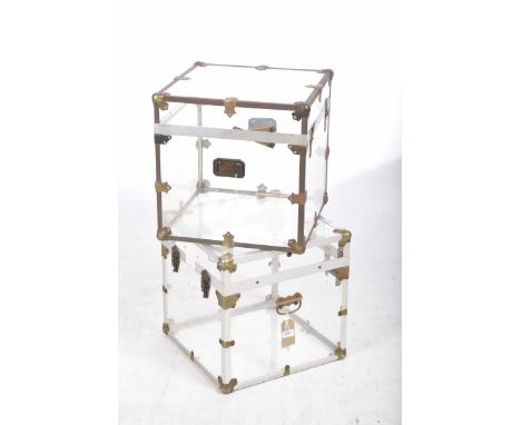A pair of contemporary metal bound perspex trunk tablesEach applied with clasp locks and swing handles, 42cm square.