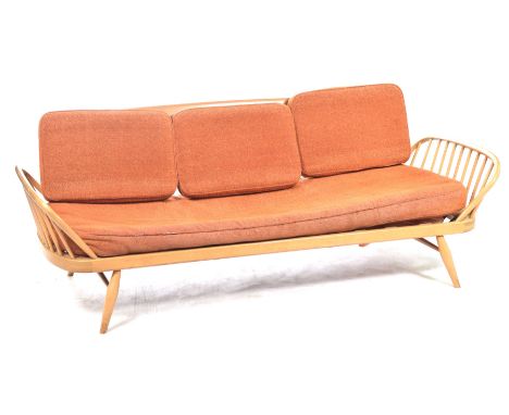 A 1960's Ercol light beech studio type settee  The rectangular board back with rounded corners enclosed by out swept arms rai