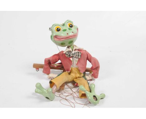 An unboxed Pelham puppet - frog In red jacket and yellow trousers.