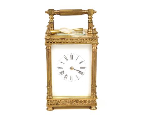 A late 19th Century brass carriage clock The case of architectural form raised on toupee feet extending to column plaster sid