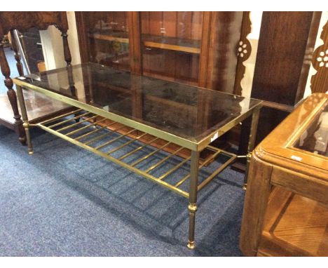 Contemporary Glass Topped Table Brass table with bottom shelf and smoked glass top. Approx dimensions 41.5 x 18 inches