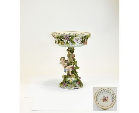 Plaue Cherub and Roses Comport, a reticulated bowl, above a tree trunk with a cherub playing on a swing hung from a branch, a