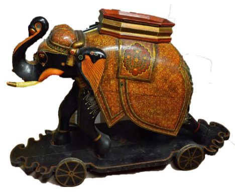 Impressive Hand Painted Large Wooden Elephant in Ebony complete with wheel base, colourfully decorated in traditional dress, 