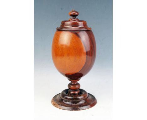 A turned Milo wood cup and cover, of plain ovoid form, the lift -off top with knopped finial, the cup of ovoid form on a knop