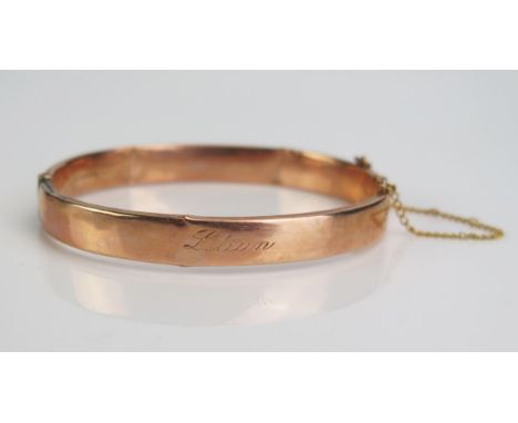A 9ct Gold Hinged Bangle engraved "Lilian", Chester hallmarks, c. 8.69g. Dented 