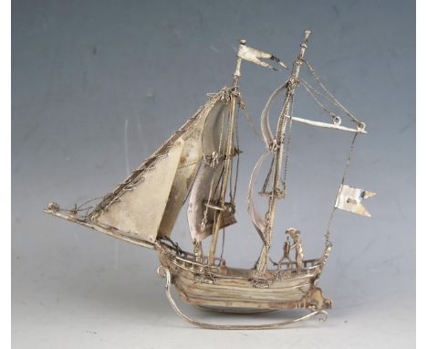A Dutch silver model of a galleon with two crew members, mounted on a rocker base, 14cm long, 91gms, 2.94ozs 