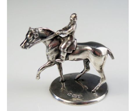 An Edward VII silver model of a horse and rider, maker John Wilmot, Birmingham, 1906, on a circular base, 6.5cm high, 127gms,