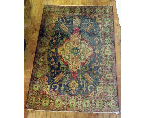 A Tabriz rug, the indigo field with central pole medallion with radiating serrated arms, with Arabic script panel within the 