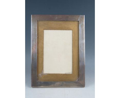 A George V silver easel photograph frame, maker's mark worn, Birmingham, 1910, of rectangular outline, 24.5 cm x 18cm. 