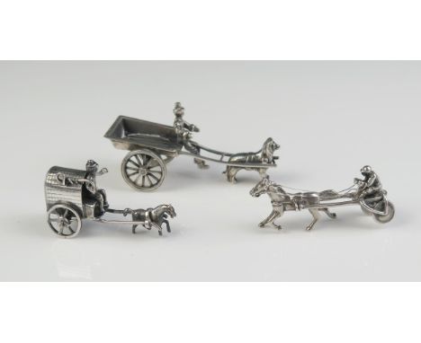 A Silver miniature model of a Sulky, a model of a silver dog cart with driver, together with a miniature silver pony trap, to