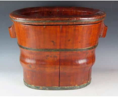 A Chinese wooden basin and stand of oval form and coopered construction, 51cm wide. 