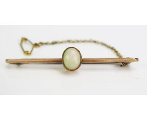 An Opal Brooch with safety chain in an unmarked precious yellow metal setting, KEE tested as 9ct+, 8x6mm stone, c. 3.47g 