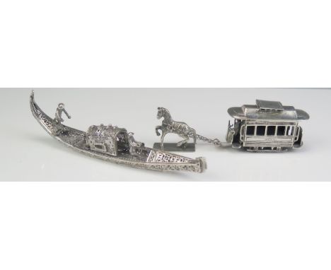 A silver filigree model of a Venetian gondola with hinged canopy, 15cm long, together with a white metal model of an American