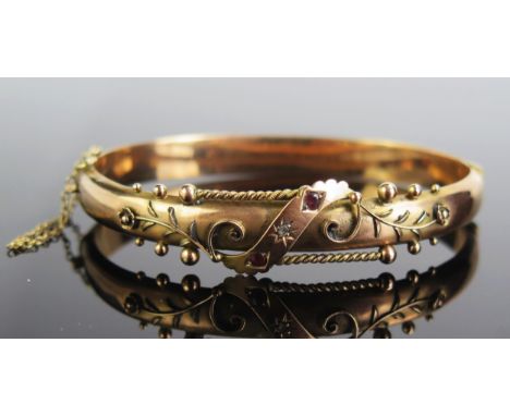 A Victorian Style 9ct Gold Hinged Bangle with foliate decoration and set with a single rose cut diamond and flanked by a garn