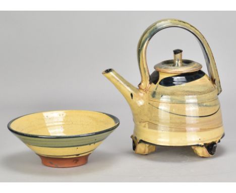 RICHARD PHETHEAN (born 1953); a slipware teapot on tripod feet, painted RP mark, height 20.5cm, and a matching bowl, diameter