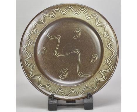 RAY FINCH (1914-2012) for Winchcombe Pottery; a stoneware charger covered in dark iron glaze with incised meander decoration,