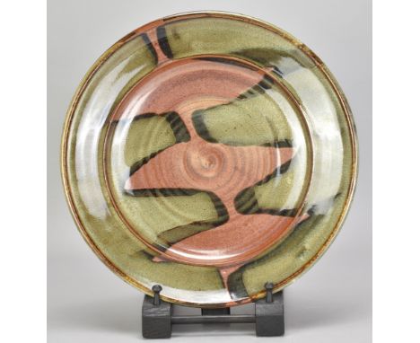 RAY FINCH (1914-2012) for Winchcombe Pottery; a large stonewareplate covered in green glaze with kaki pours, impressed WP. ma